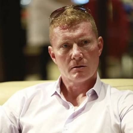 Red Shea seated in a white shirt.
